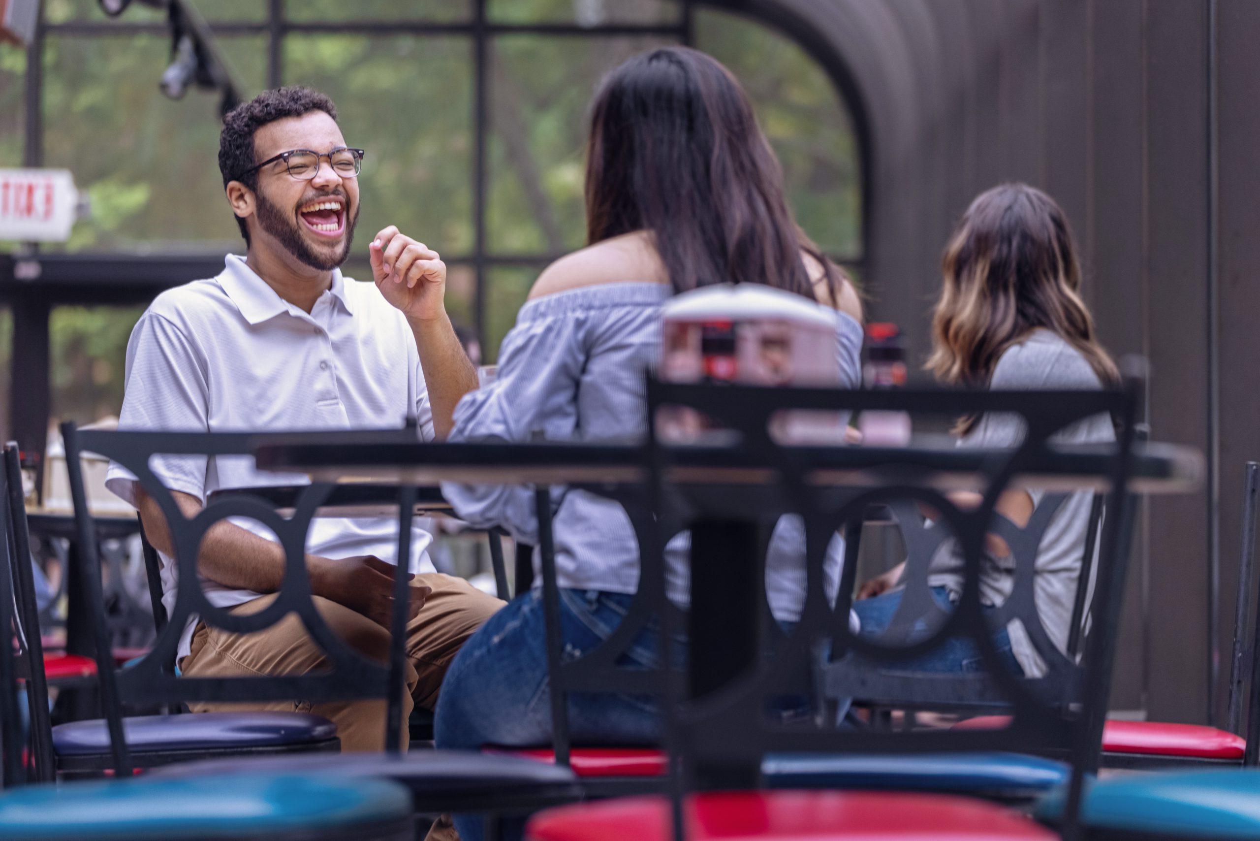 Students laughing during a conversation at a table in Anna Irvin Dining Hall.